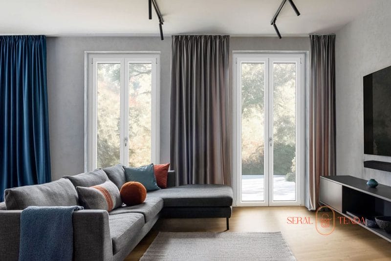 Un soggiorno moderno con tende blu e finestre in alluminio a Lodi.