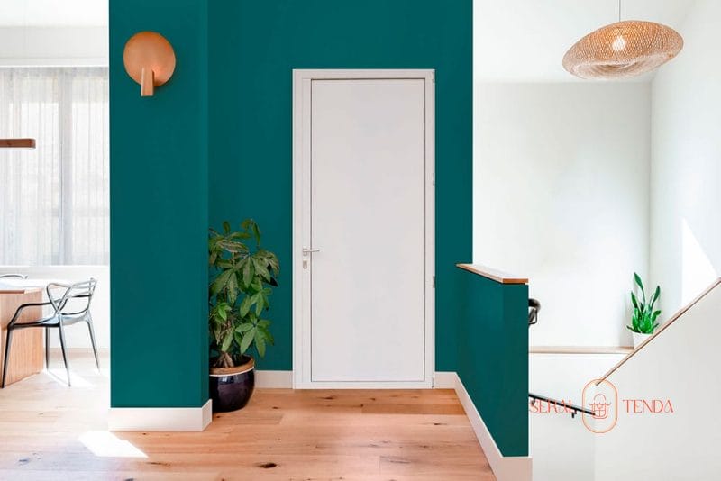 Un soggiorno con pareti verde acqua e pavimenti in legno decorati con Serramenti in alluminio Lodi.