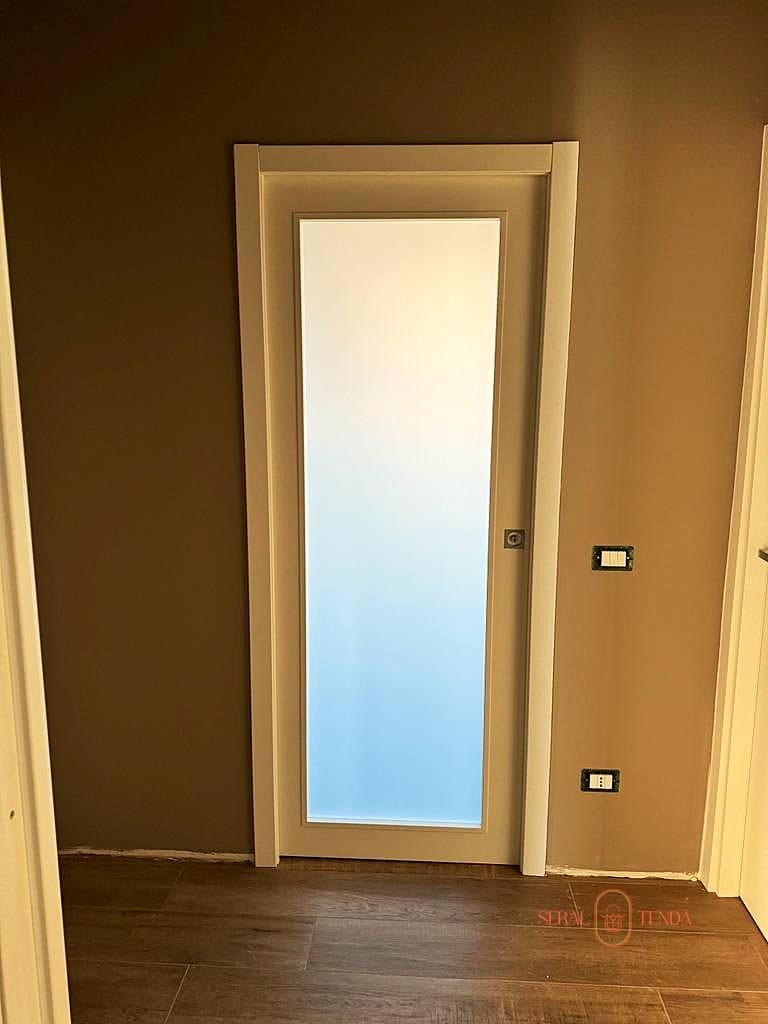 Installazione di una porta in vetro smerigliato in una stanza.